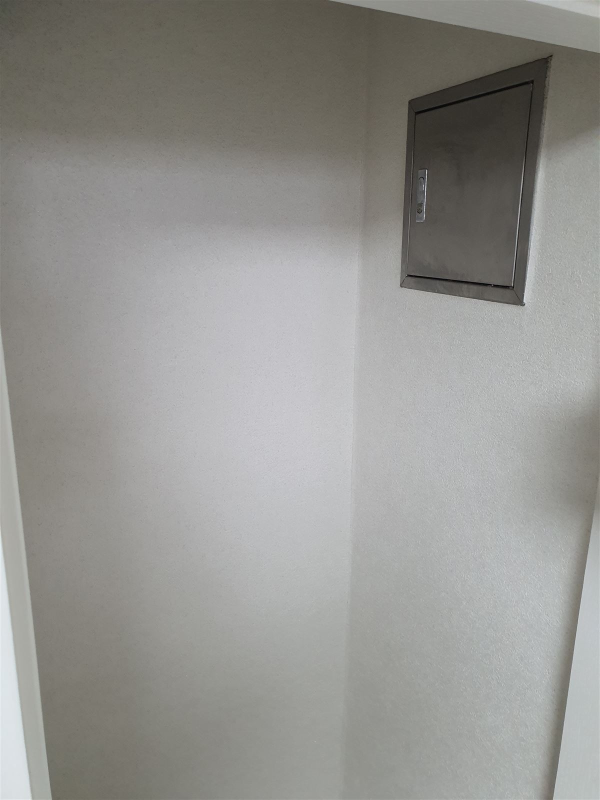 선반 없이 벽과 점검구만 있는 빈 펜트리